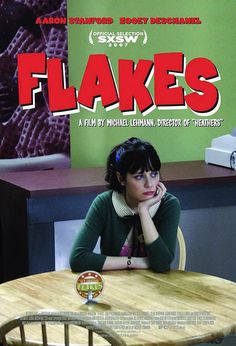 a woman sitting at a table in front of a tv screen with the words flakes on it