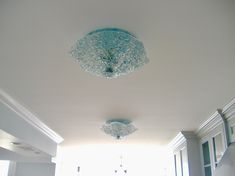 the light fixture is hanging from the ceiling in the room with white walls and blue trim