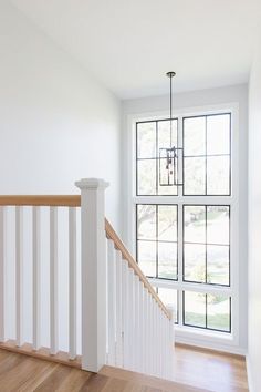 an empty room with wood floors and white railings