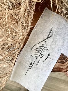 a piece of paper sitting on top of a wooden table next to some dry grass