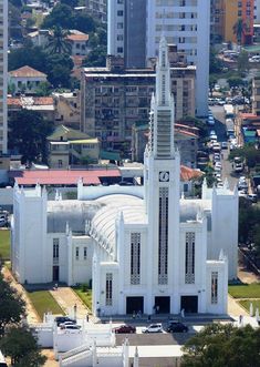 an aerial view of a white church in the middle of a city with tall buildings