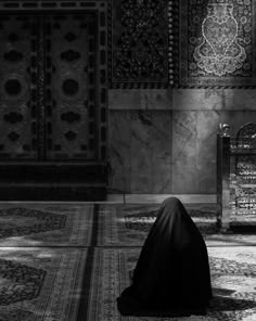 a woman in a black dress sitting on the floor