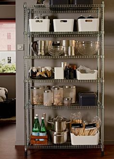 a metal shelving unit filled with lots of food and drinks on top of a wooden floor