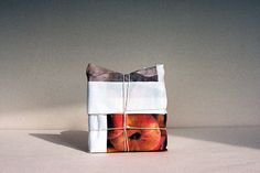 an apple wrapped in white paper on top of a table