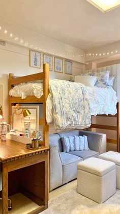 a loft bed sitting above a white couch in a living room next to a desk