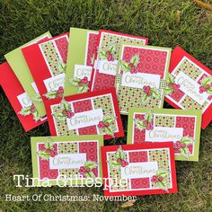 six christmas cards laid out on the grass with green and red trimmings, one has