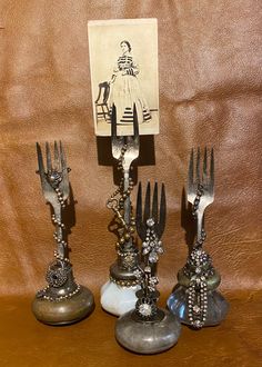 three forks are sitting next to each other on top of a wooden table with an old photo