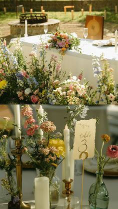 a table topped with lots of vases filled with different types of flowers and candles