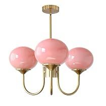 three pink balls are hanging from a brass chandelier with four lights on each end