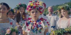 a group of people standing next to each other with flowers in their hair and wreaths on their heads