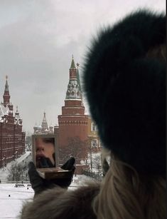 a person taking a photo with their cell phone in front of the kreme tower