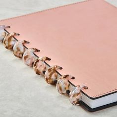 a pink notebook with shells on the cover