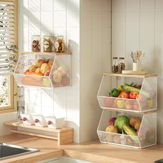 two clear containers filled with fruits and vegetables on top of a counter next to a sink