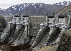 a large dam with mountains in the background