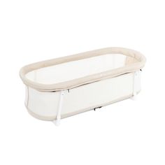 the baby crib is white and has a beige lining on it's sides