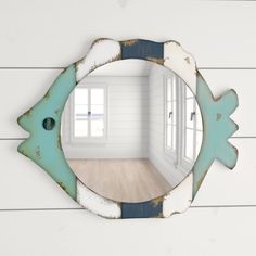 a fish shaped mirror hanging on the wall