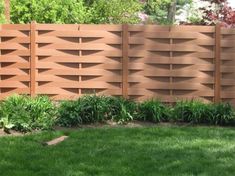 a wooden fence in the middle of some grass