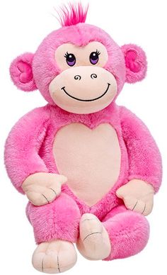 a pink monkey stuffed animal sitting on top of a white surface with its hands in the air