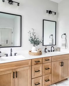 a bathroom with double sinks and mirrors on the wall