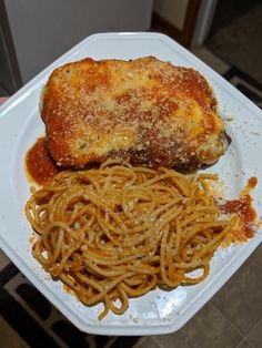 a white plate topped with spaghetti and meat