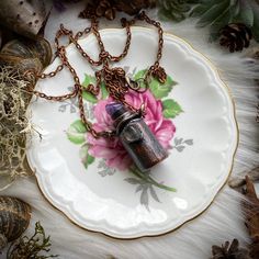 a necklace with a flower on it sitting on top of a plate