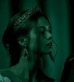 a woman wearing a tiara in the dark