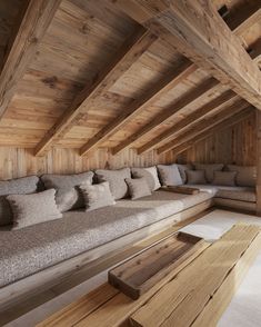 a room filled with lots of couches and wooden beams on the wall above them