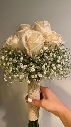 a person holding a bouquet of white roses