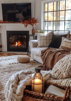 a living room filled with furniture and a fire place next to a window covered in blankets