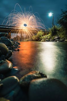 fireworks are lit up over the water and rocks