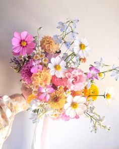 a vase filled with lots of different colored flowers