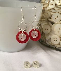 a pair of red and white buttons sitting on top of a table next to a cup