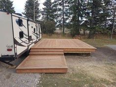 an rv is parked in the woods next to some steps