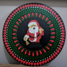 a decorative painting on the wall with red and green dots around it, depicting a santa clause