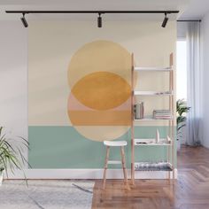 an abstract painting on the wall next to a chair and table with a plant in it