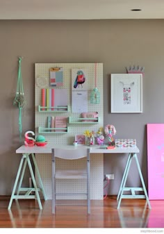 an image of a desk with pictures on the wall above it and below that is a pink refrigerator