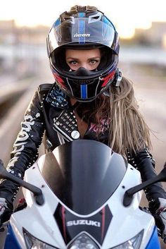 a woman wearing a helmet is sitting on a motorcycle