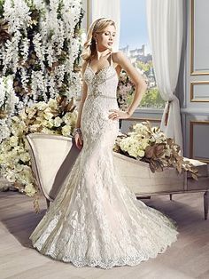 a woman in a wedding dress standing next to a flower filled room with white flowers