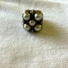 a close up of a ring with pearls on it