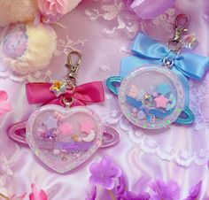 two keychains that are on top of a table with flowers and teddy bears