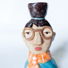 a ceramic figurine with glasses and a hat on it's head is shown