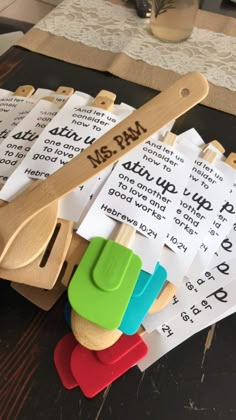 several wooden spoons and pieces of paper with words on them sitting next to each other