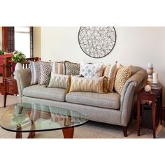 a living room filled with furniture and a glass top coffee table in front of it