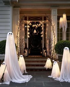 halloween decorations with ghost heads and lights in front of a house