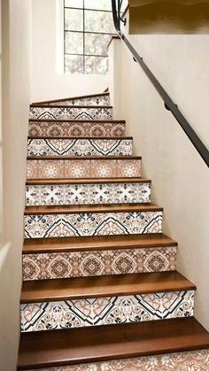 the stairs are decorated with blue and white tile designs, along with an iron handrail