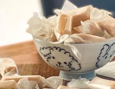 a bowl filled with lots of brown and white pieces of food on top of a wooden table