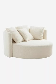 a white couch with pillows on it in the shape of a circle, against a white background