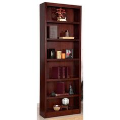 a wooden bookcase with many books on the shelves and two vases in front of it