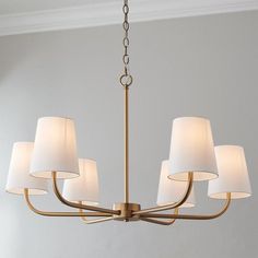 a chandelier with six lamps hanging from it's sides in a room