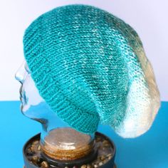 a knitted hat sitting on top of a glass head mannequin's head